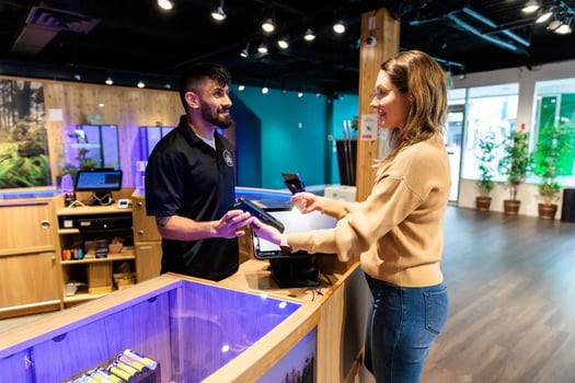 Medewerker helpt een klant aan de toonbank van een coffeeshop