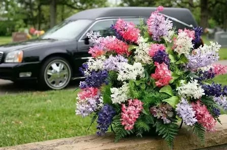 Rouwauto met bloemstuk bij een uitvaart
